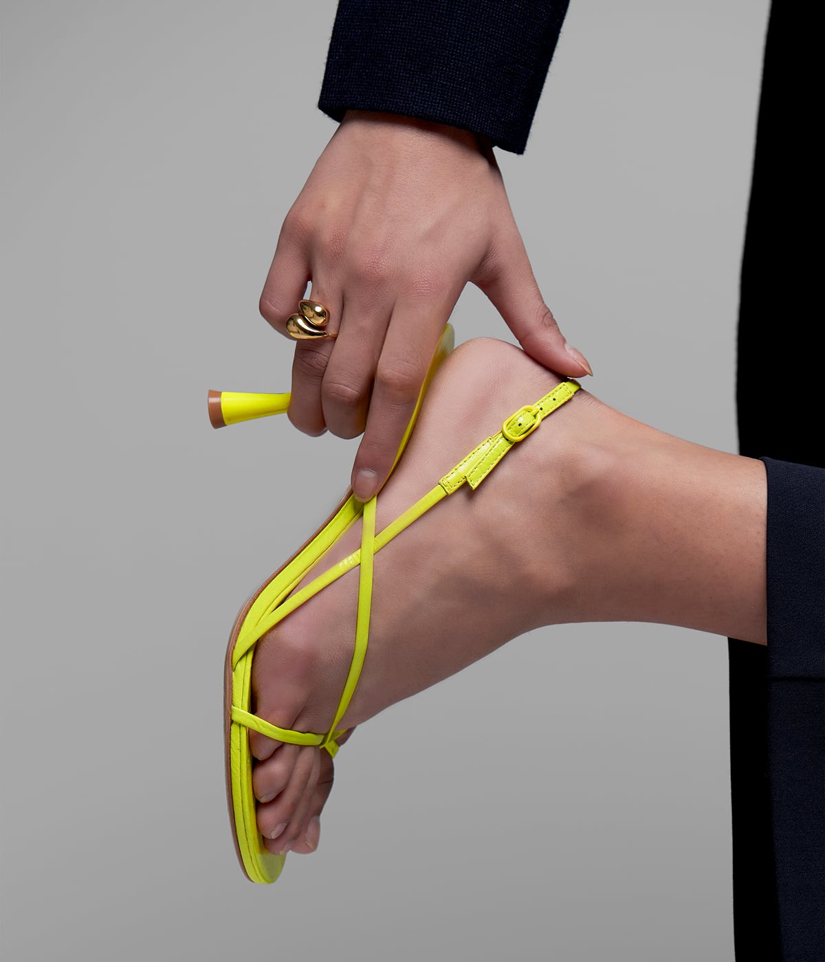 Close-up of a high-heeled shoe being worn, with a hand gently holding the heel. The product comes to life: tactile experience, digital identity, and invisi
