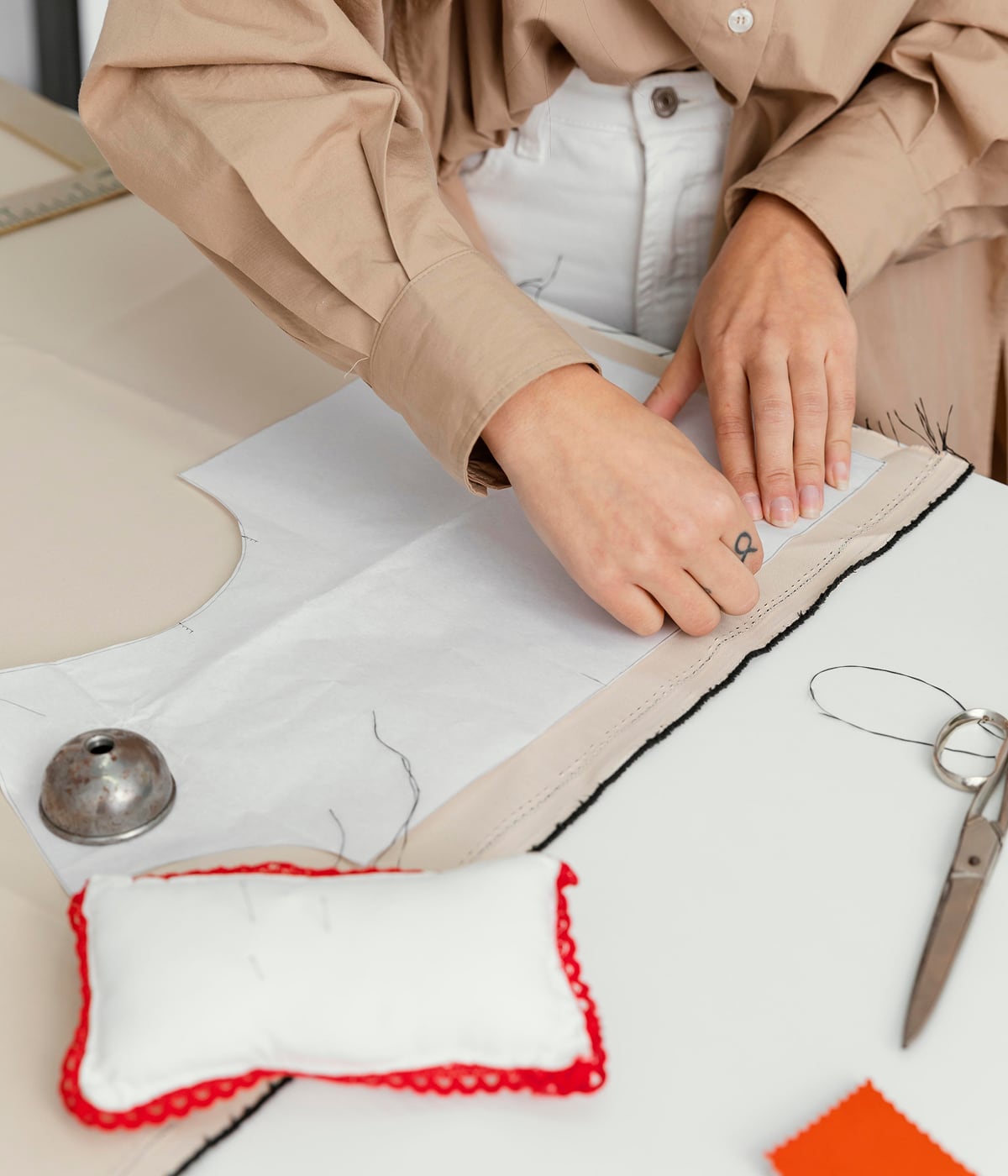 Styliste travaillant dans son atelier, créant des modèles exclusifs avec une attention méticuleuse aux détails. La technologie Temera soutient chaque étape