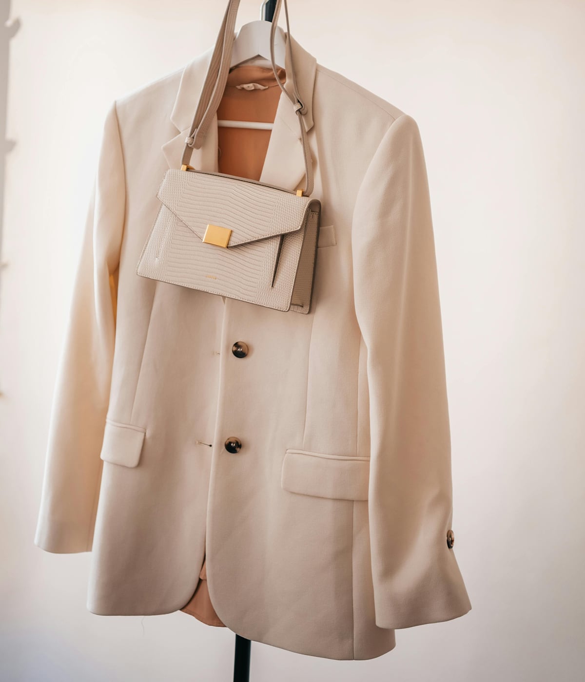 Un blazer et un sac suspendus, symbole d'élégance et de qualité. Grâce à la technologie RFID de Temera, chaque produit est suivi avec précision, garantissa